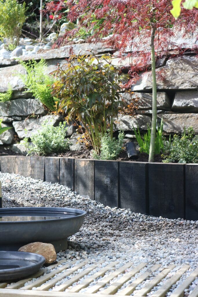 Blomsterbed med jernbanesviller som omramming.