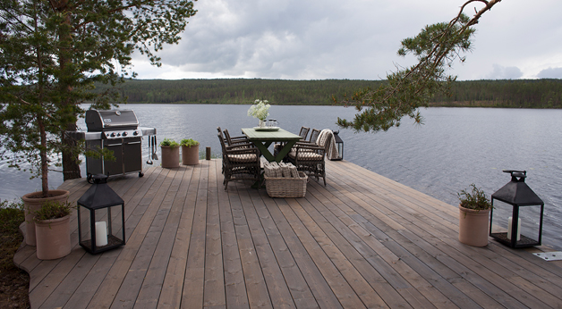 Eventyrlig oppussing. Terrasse i MøreRoyal UNO grå. Spiseområde ved innsjø.