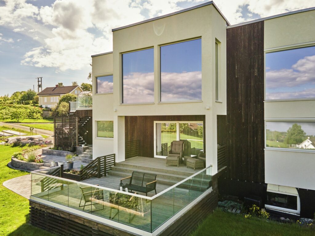 Moderne enebolig på Toten i MøreRoyal setersvart. Forside og terrasse på bakkeplan.