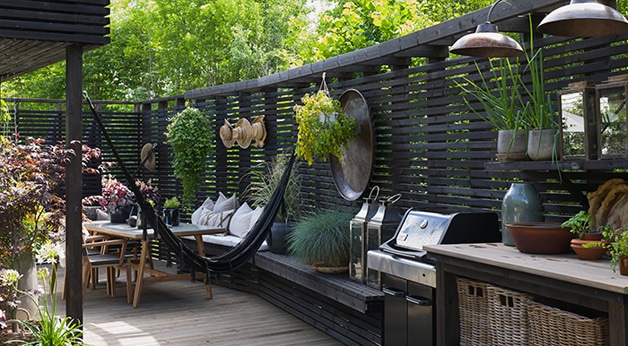 Hjemme hos Marianne Stensrud - foto fra uterom med spilerekkverk, sittegruppe og hengekøye