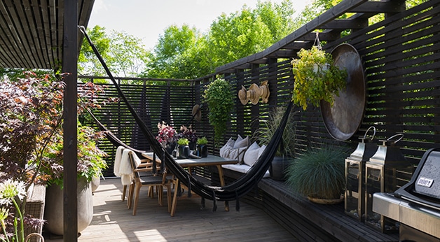 Hjemme hos Marianne Stensrud - foto fra uterom med spilerekkverk, sittegruppe og hengekøye