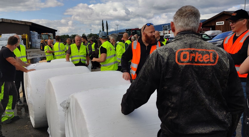 Talgø og Orkel demonstrerer pressing av dyrestrø til rundballer - Orkel forklarer for publikum