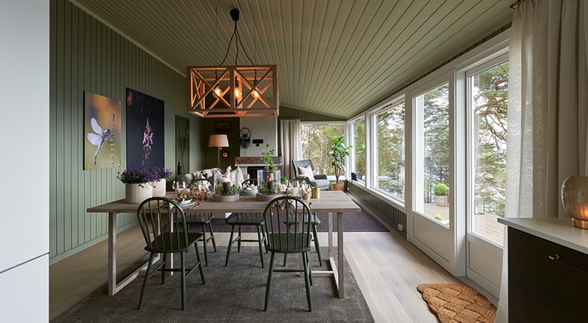 Eventyrlig oppussing. Interiør fra stue med grønne vegger, lys spisestue med mørkegrønne stoler.