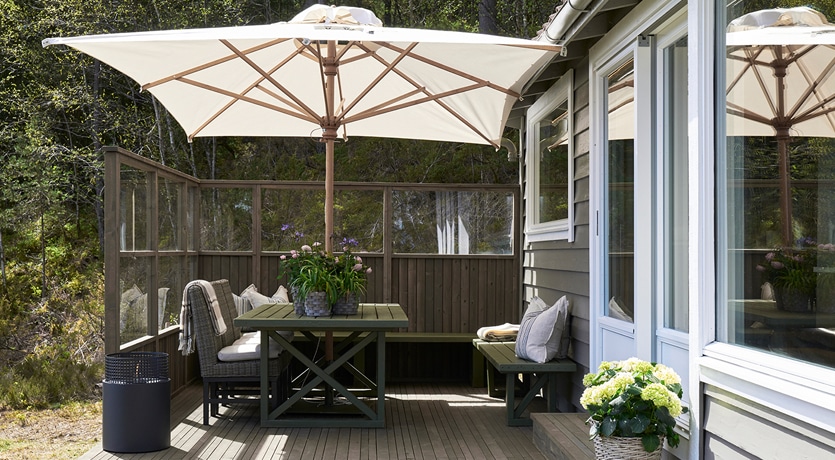 Eventyrlig Oppussing - Os - Foto av terrasse i MøreRoyal med levegger, alt i grå. Hyggelig spisegruppe. Parasoll gir skygge.