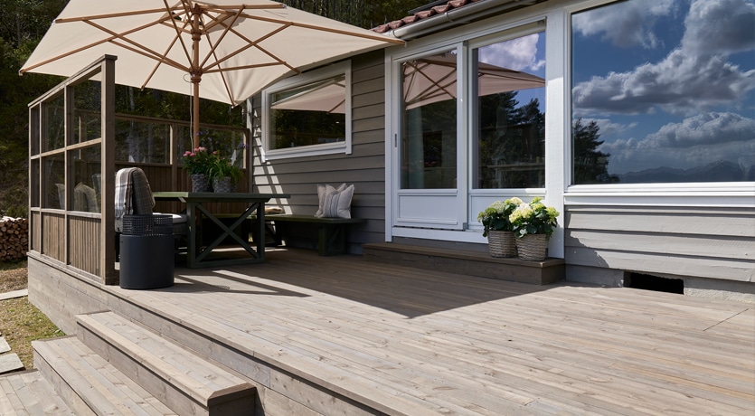 Eventyrlig Oppussing - Os - Foto av terrasse i MøreRoyal med levegger, alt i grå. Hyggelig spisegruppe. Parasoll gir skygge.