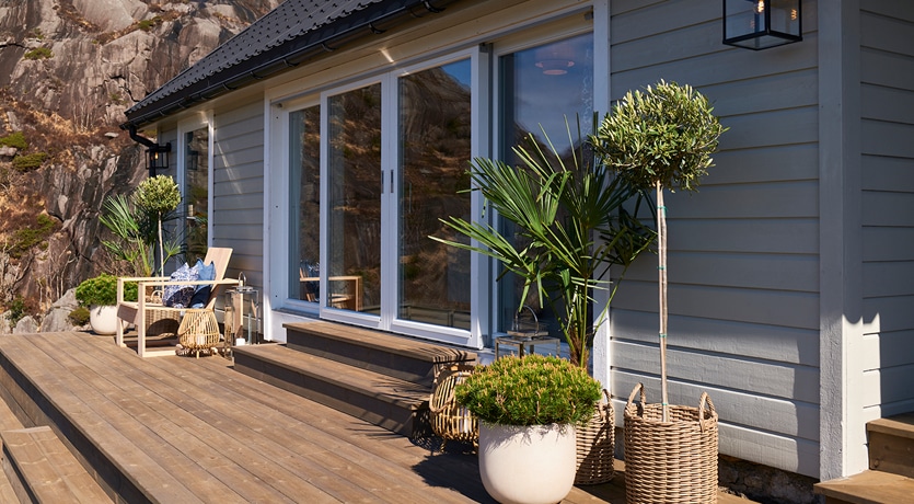 Eventyrlig oppussing, episode 3, sesong 7. Fasadefoto av ferdig oppusset hytte. Lekker terrasse i MøreRoyal grå.