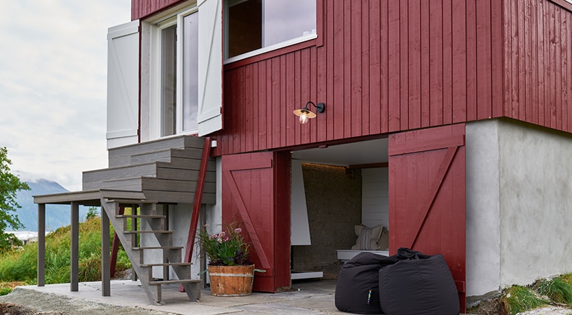 Eventyrlig Oppussing - Sommarøy - eksteriør av restaurert låve i rødt. Trapp ned til utestue i gammel fraukjeller.