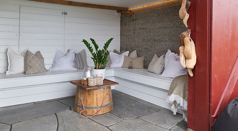 Eventyrlig Oppussing - Sommarøy - utestue i gammel fraukjeller. Hvite benker med lyse tekstiler..